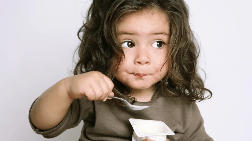 girl eating yogurt Girl eating yogurt