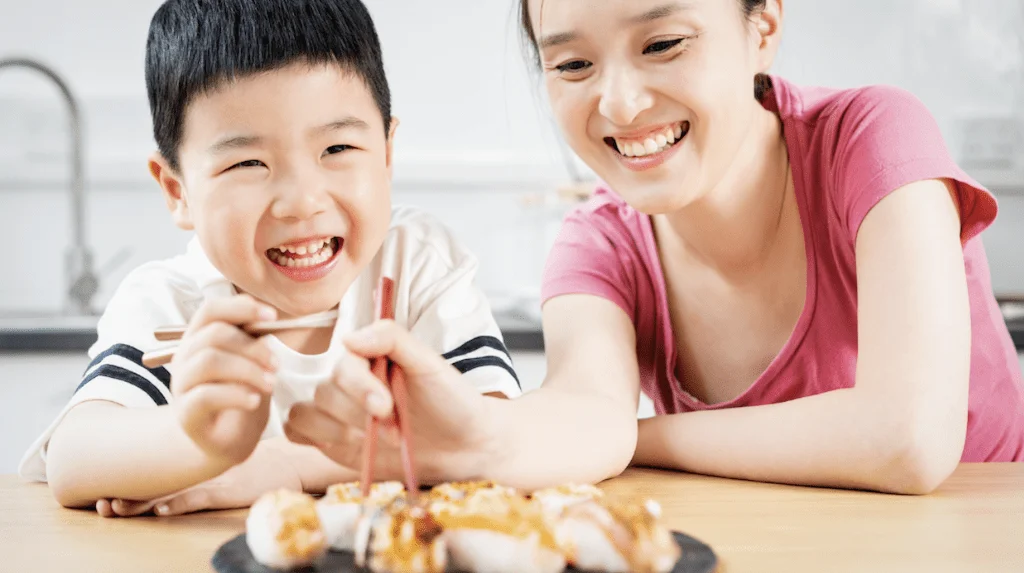 mother and son eating sushi Mother and son eating sushi